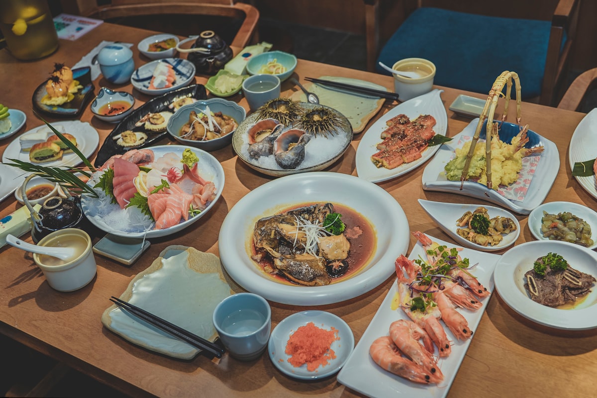 Different foods in plates on brown wooden dining table