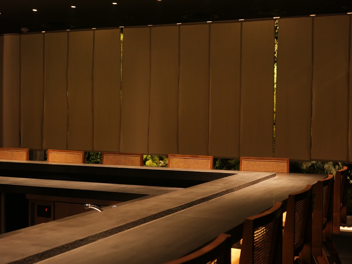 A row of wooden benches sitting next to a wall